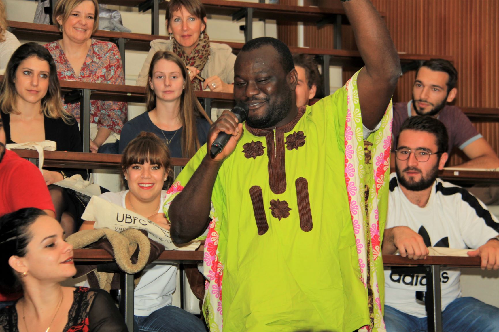 Un étudiant de Sierra Léone souriant tenant un microphone dans un amphithéâtre